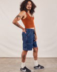 Side view of Carpenter Shorts in Dark Wash and burnt terracotta Cropped Tank on Jesse
