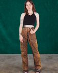 Hana is 5'3' and wearing XXS Leopard Work Pants and black Halter Top