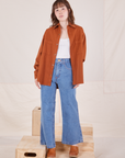 Hana is wearing Oversize Overshirt in Burnt Terracotta paired with vintage off-white Cropped Tank Top and light wash Sailor Jeans