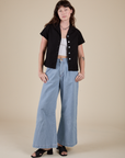Alex is wearing Pantry Button-Up in Basic Black and light wash Indigo Wide Leg Trousers