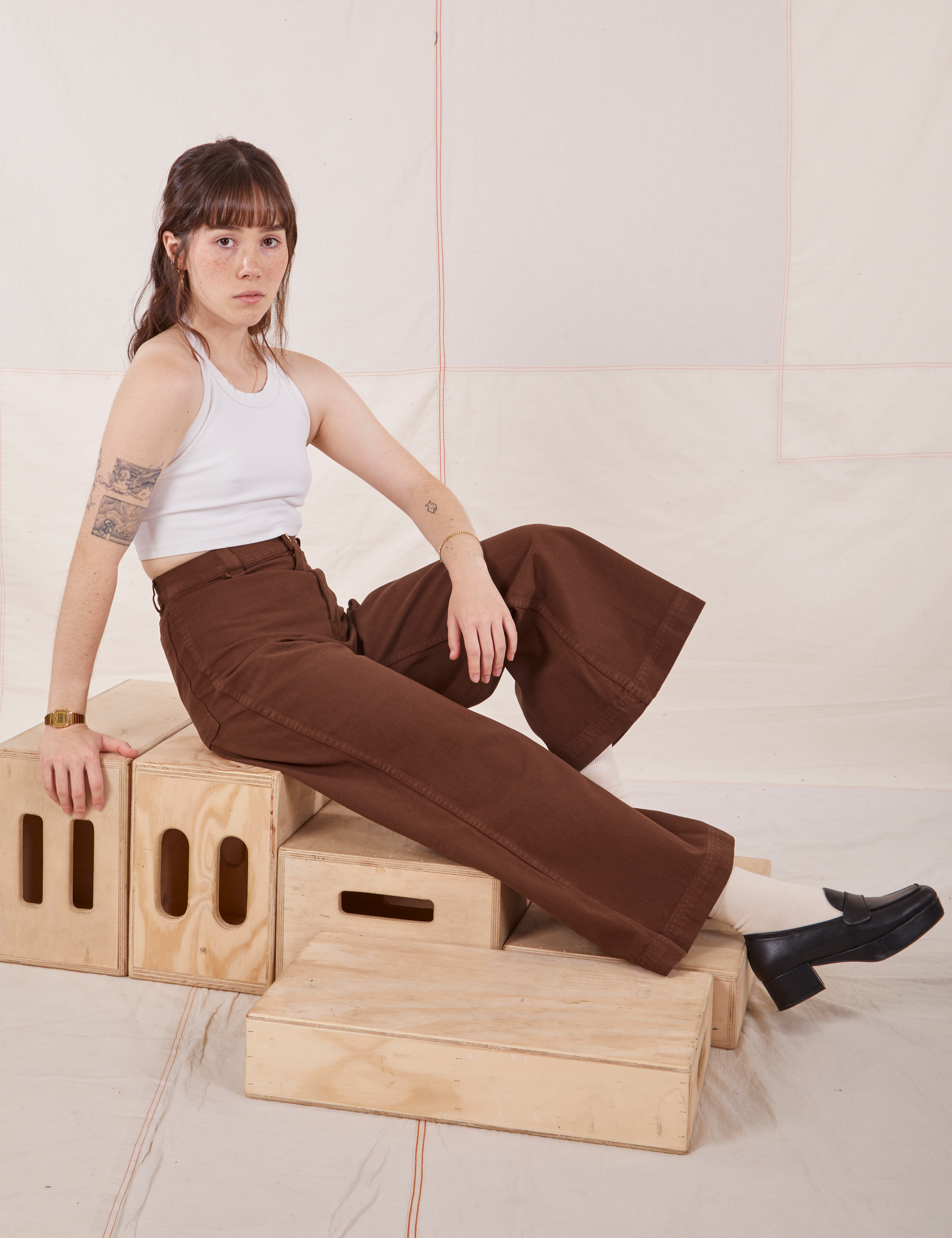 Hana is wearing Petite Bell Bottoms in Fudgesicle Brown and Halter Top in vintage tee off-white