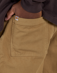 Close up of Isaac's hand in the front pocket of Longline Work Shorts in Desert Brown