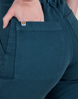 Close up of Alex's hand in the back pocket of Short Sleeve Jumpsuit in Lagoon