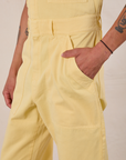 Close up of Anthony's hand in the front pocket of Short Sleeve Jumpsuit in Butter Yellow