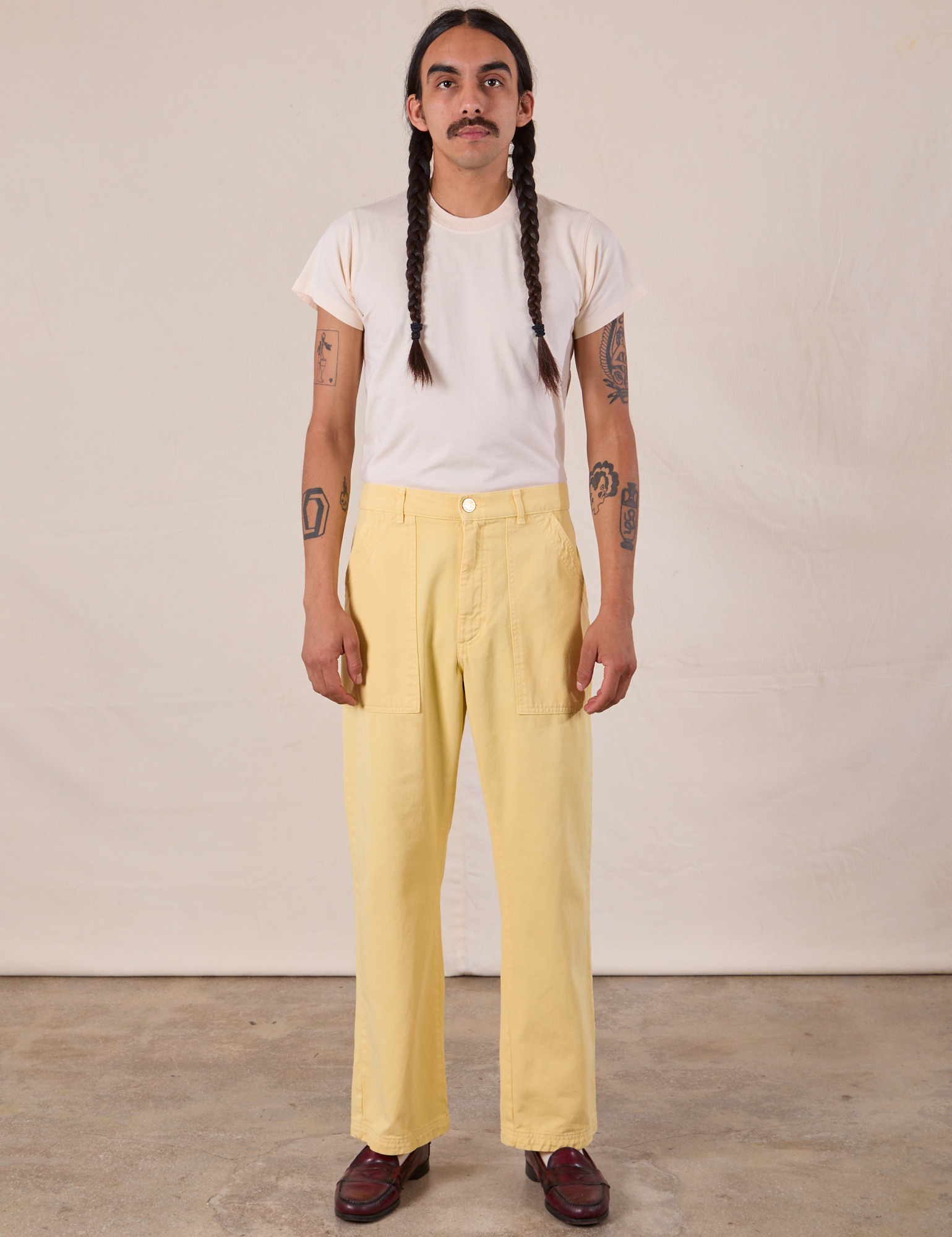Anthony is 5'10" and wearing S Work Pants in Butter Yellow paired with an Organic Vintage Tee in Vintage Tee Off-White