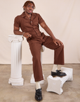 Issac is wearing Short Sleeve Jumpsuit in Fudgesicle Brown