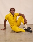 Issac is wearing Short Sleeve Jumpsuit in Golden Yellow