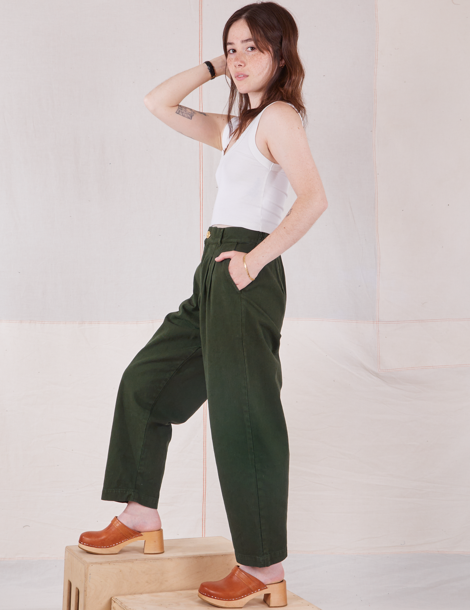 Side view of Heavyweight Trousers in Swamp Green and Cropped Tank Top in vintage tee off-white on Hana