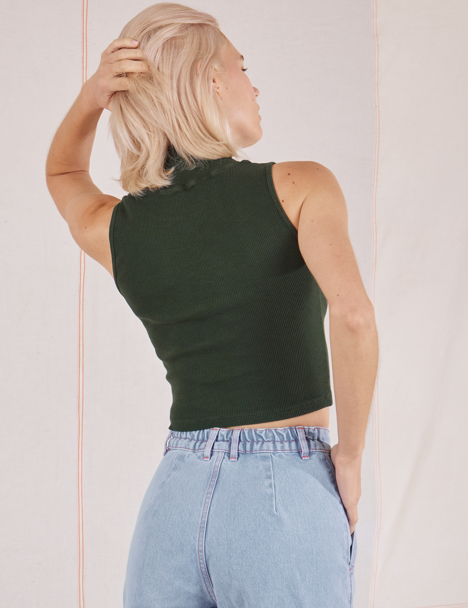 Sleeveless Essential Turtleneck in Swamp Green back view on Madeline