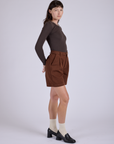 Side view of Pleated Trouser Shorts in Fudgesicle Brown and Long Sleeve Baby Tee in Espresso Brown