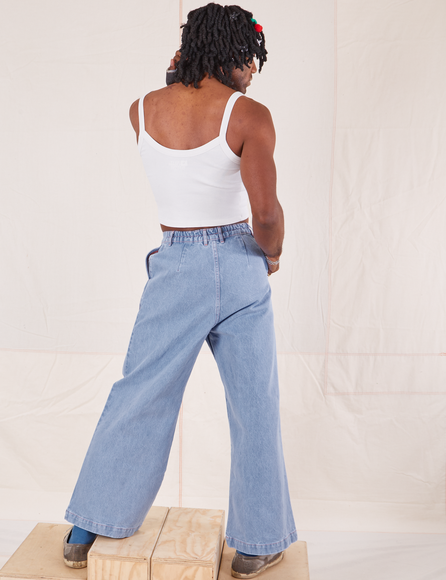 Back view of Indigo Wide Leg Trousers in Light Wash and vintage off-white Cami on Jerrod