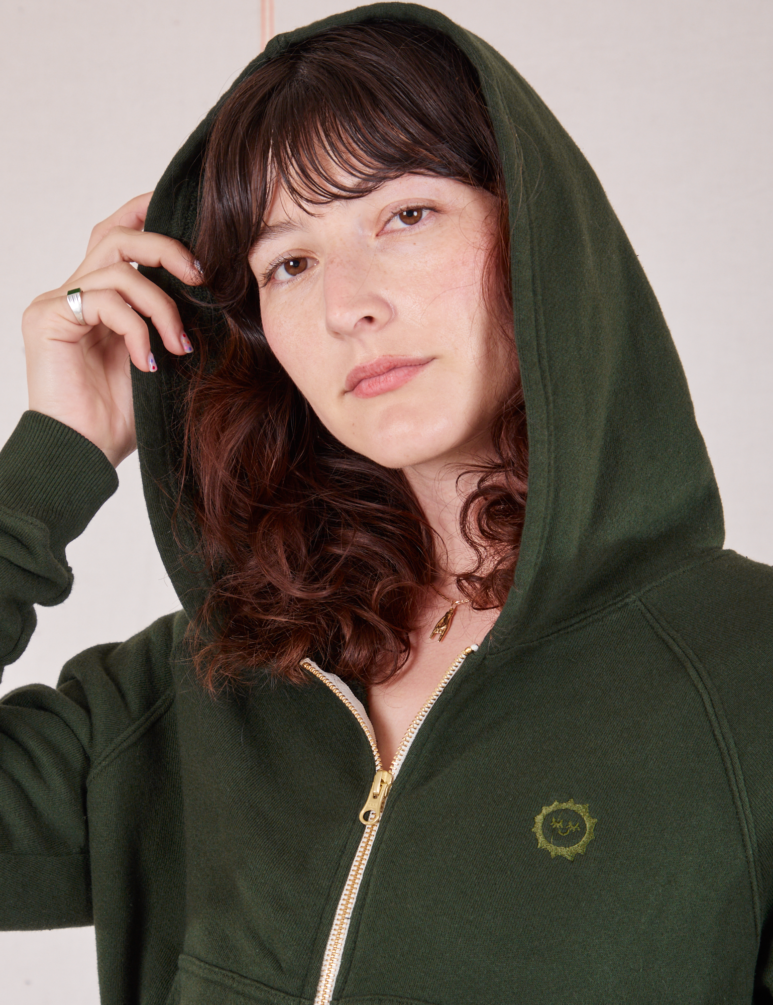 Alex is wearing Cropped Zip Hoodie in Swamp Green with the hood up