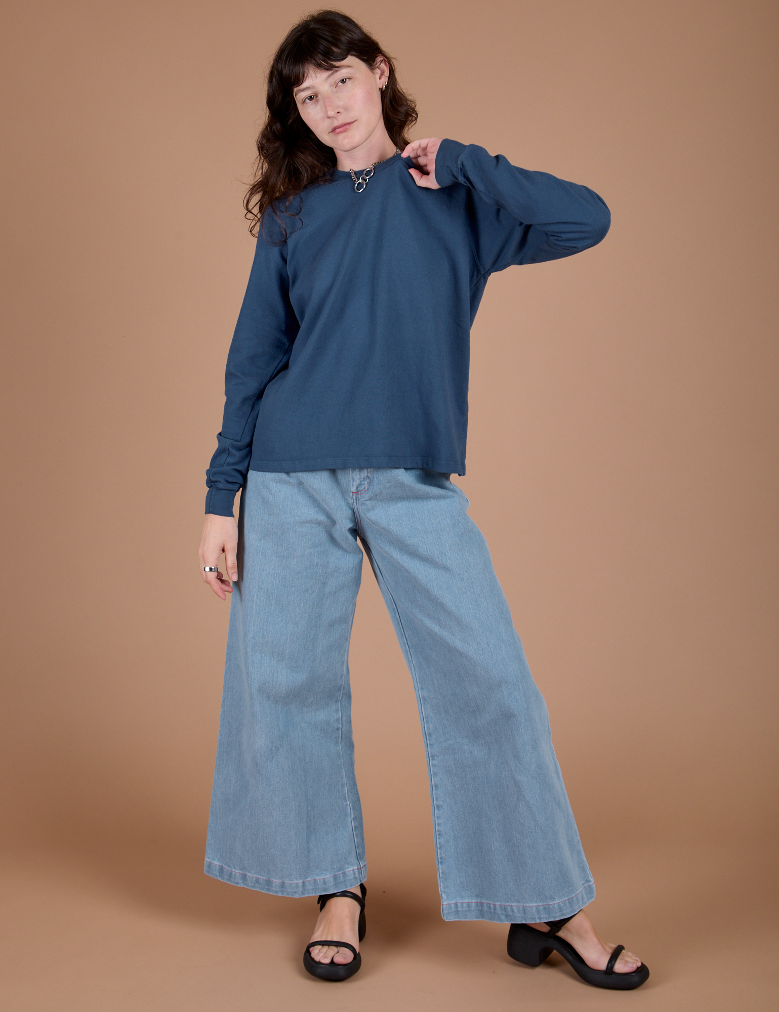 Alex is wearing Long Sleeve Burly Tee in French Blue and light wash Indigo Wide Leg Trousers