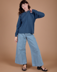 Alex is wearing Long Sleeve Burly Tee in French Blue and light wash Indigo Wide Leg Trousers