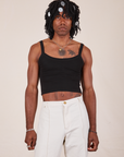 Jerrod is wearing S Cropped Cami in Basic Black paired with vintage off-white Western Pants