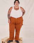 Sam is 5'10" and wearing 3XL Carpenter Jeans in Burnt Terracotta paired with Tank Top in vintage tee off-white