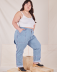 Angled front view of Carpenter Jeans in Light Wash and Cropped Cami in vintage tee off-white worn by Ashley