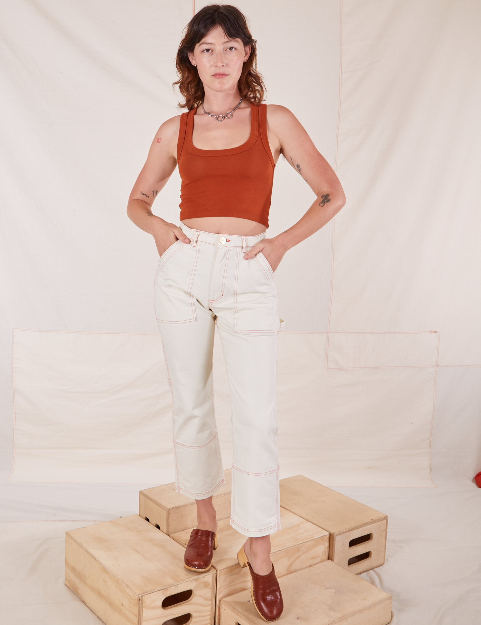 Alex is wearing Carpenter Jeans in Vintage Tee Off-White and burnt terracotta Cropped Tank Top