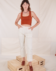 Alex is wearing Carpenter Jeans in Vintage Off-White and burnt terracotta Cropped Tank Top