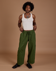 Jerrod is wearing Drop Pocket Cargo Pants in Evergreen and Tank Top in vintage tee white