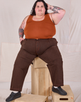 Sam is wearing Overdyed Denim Trouser in Fudge and burnt terracotta Cropped Tank