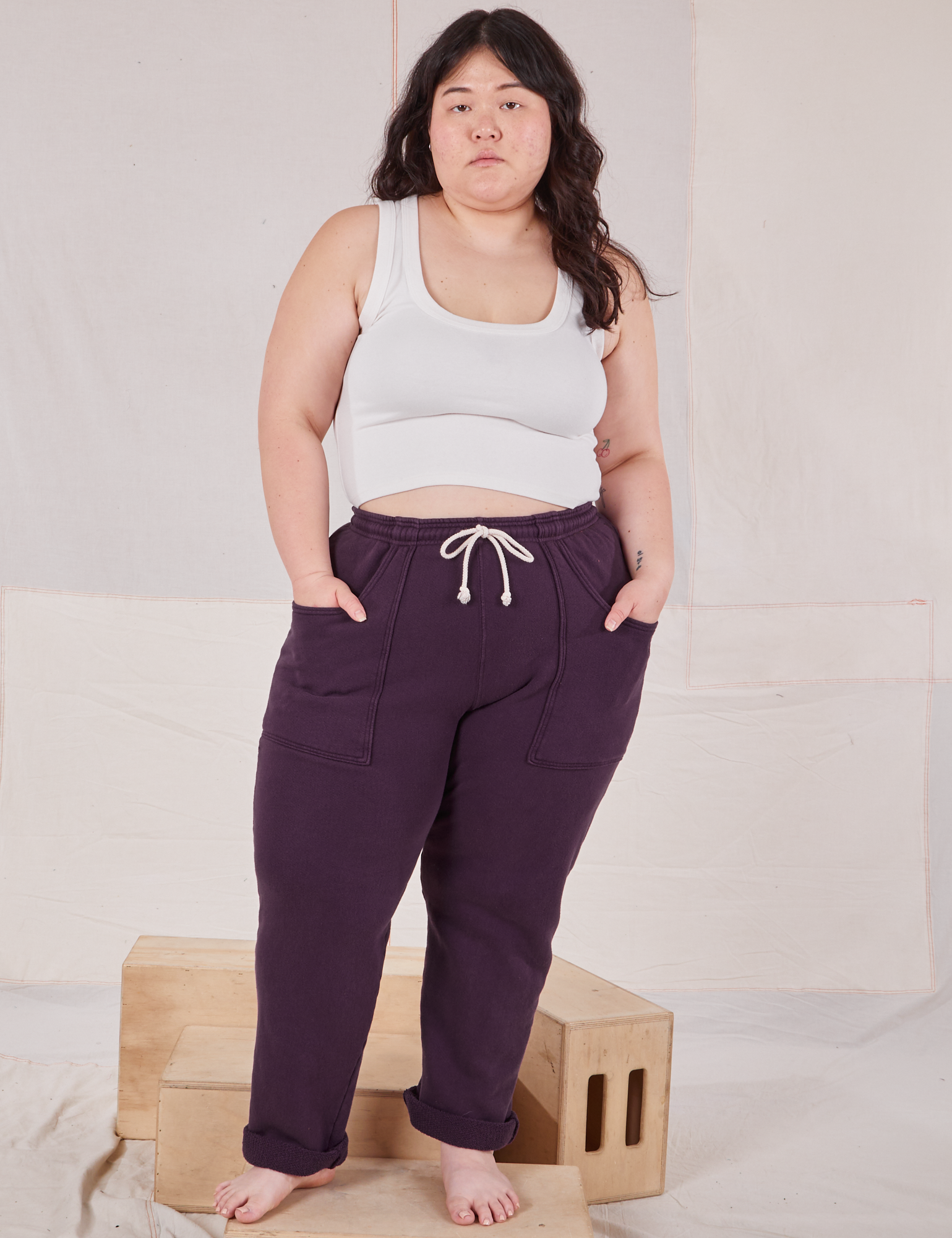 Ashley is 5&#39;7&quot; and wearing L Rolled Cuff Sweat Pants in Nebula Purple paired with vintage off-white Cropped Tank