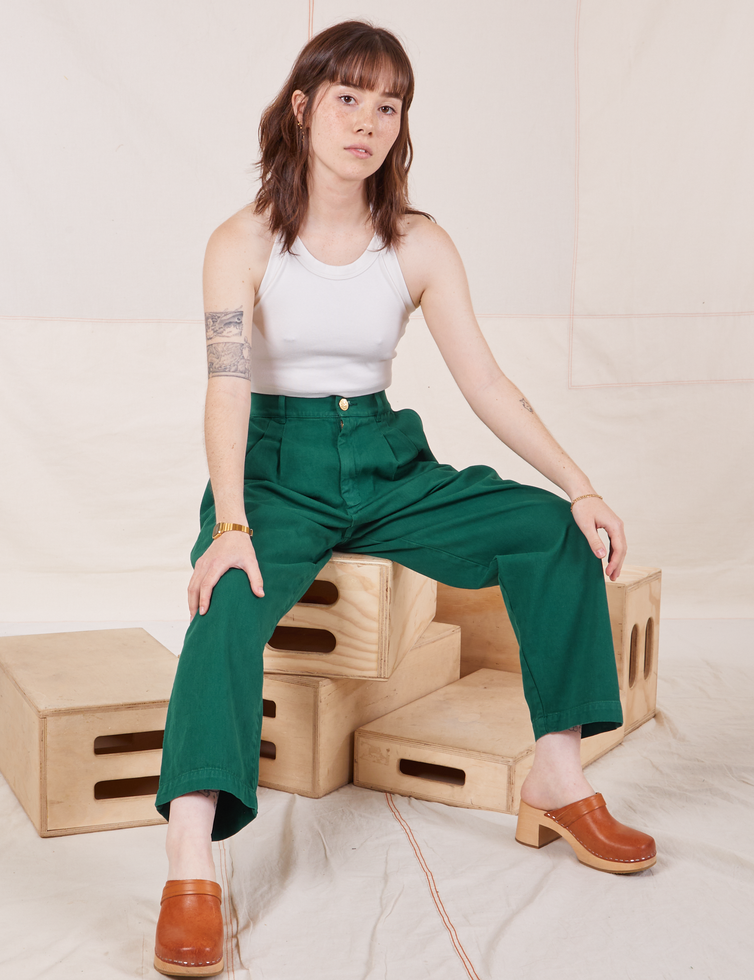 Hana is wearing Heavyweight Trousers in Hunter Green and vintage off-white Halter Top