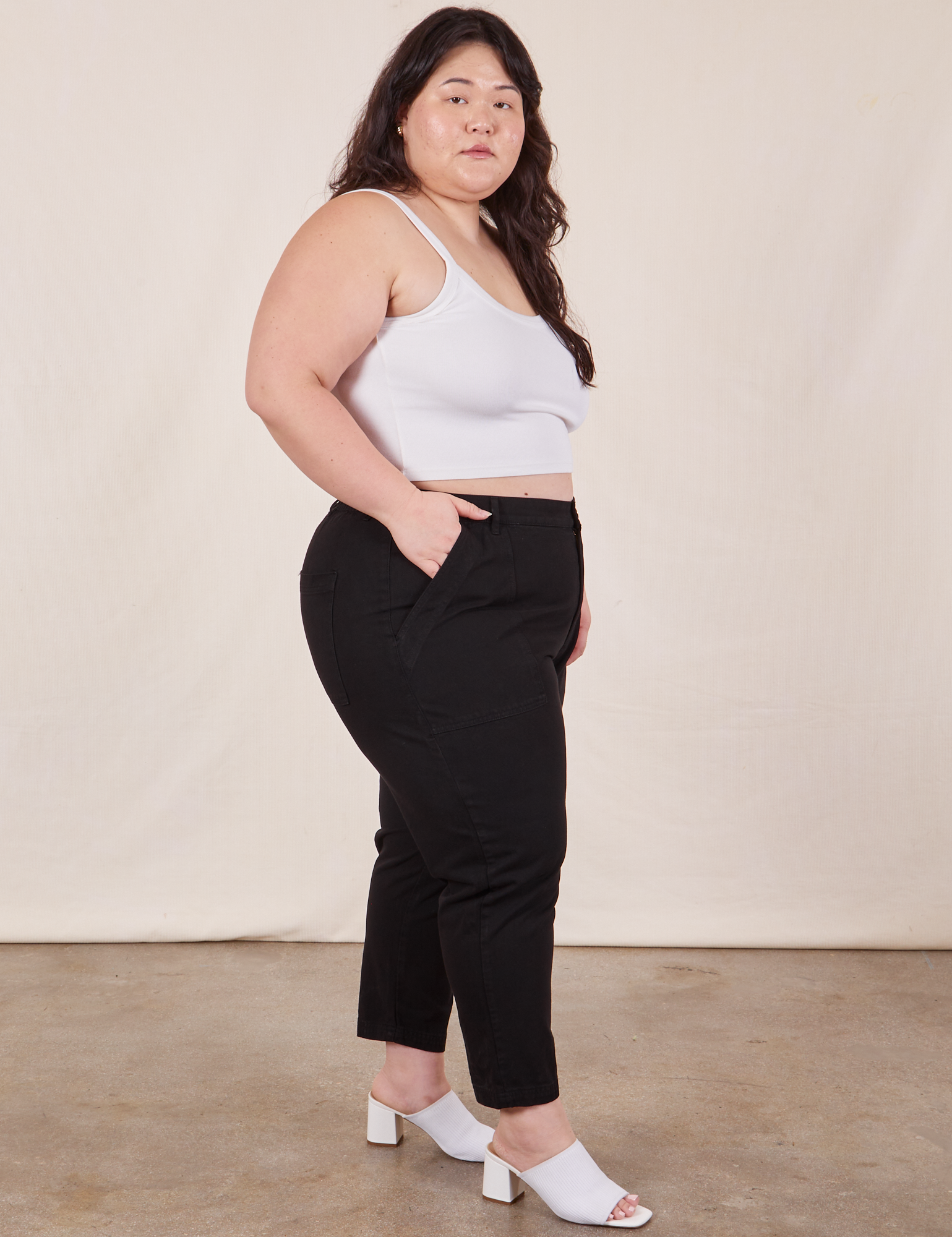 Side view of Petite Pencil Pants in Basic Black and vintage off-white Cropped Cami on Ashley