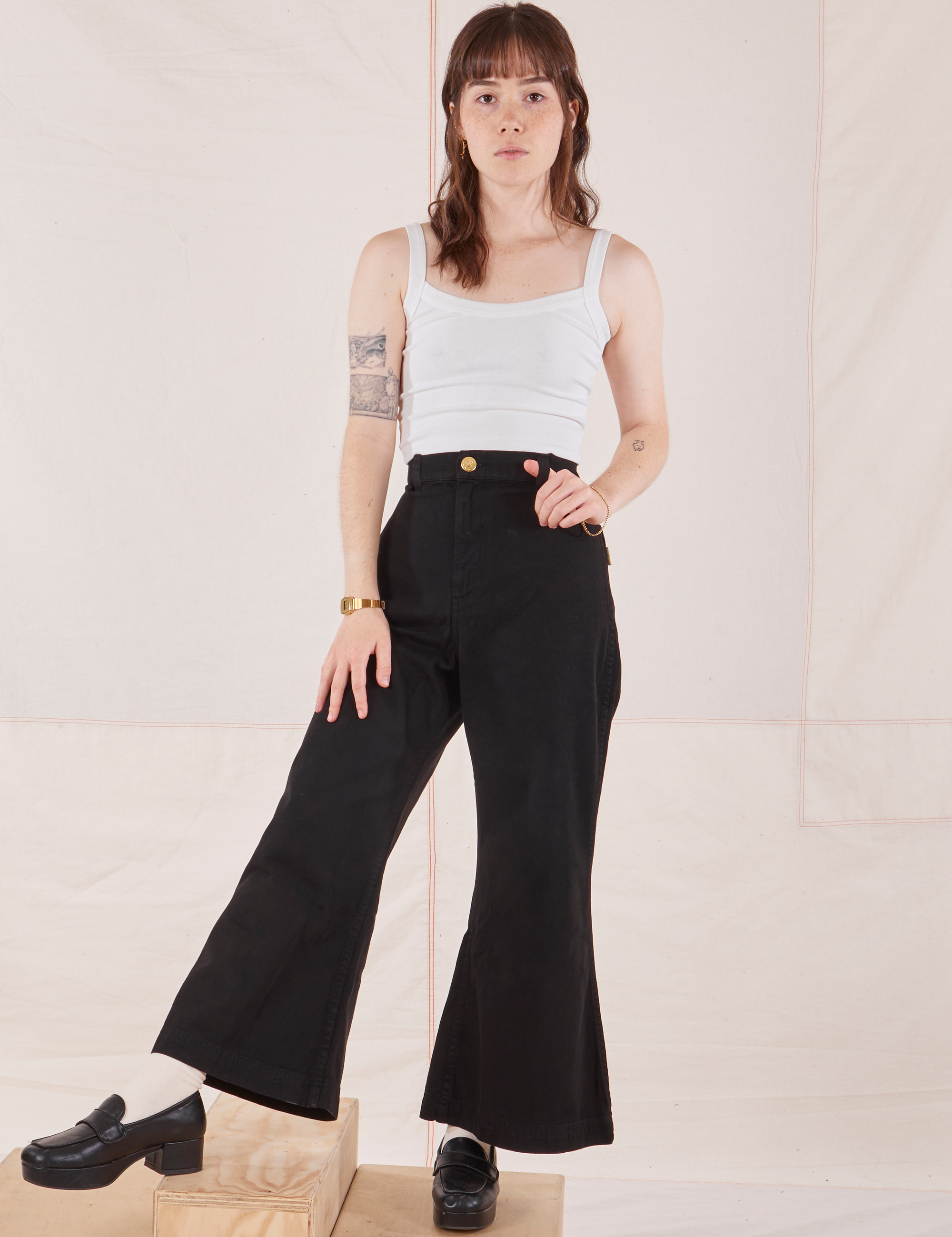 Hana is 5&#39;3&quot; and wearing P Petite Bell Bottoms in Basic Black paired with Cropped Cami in vintage tee off-white