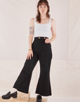 Hana is 5'3" and wearing P Petite Bell Bottoms in Basic Black paired with Cropped Cami in vintage tee off-white