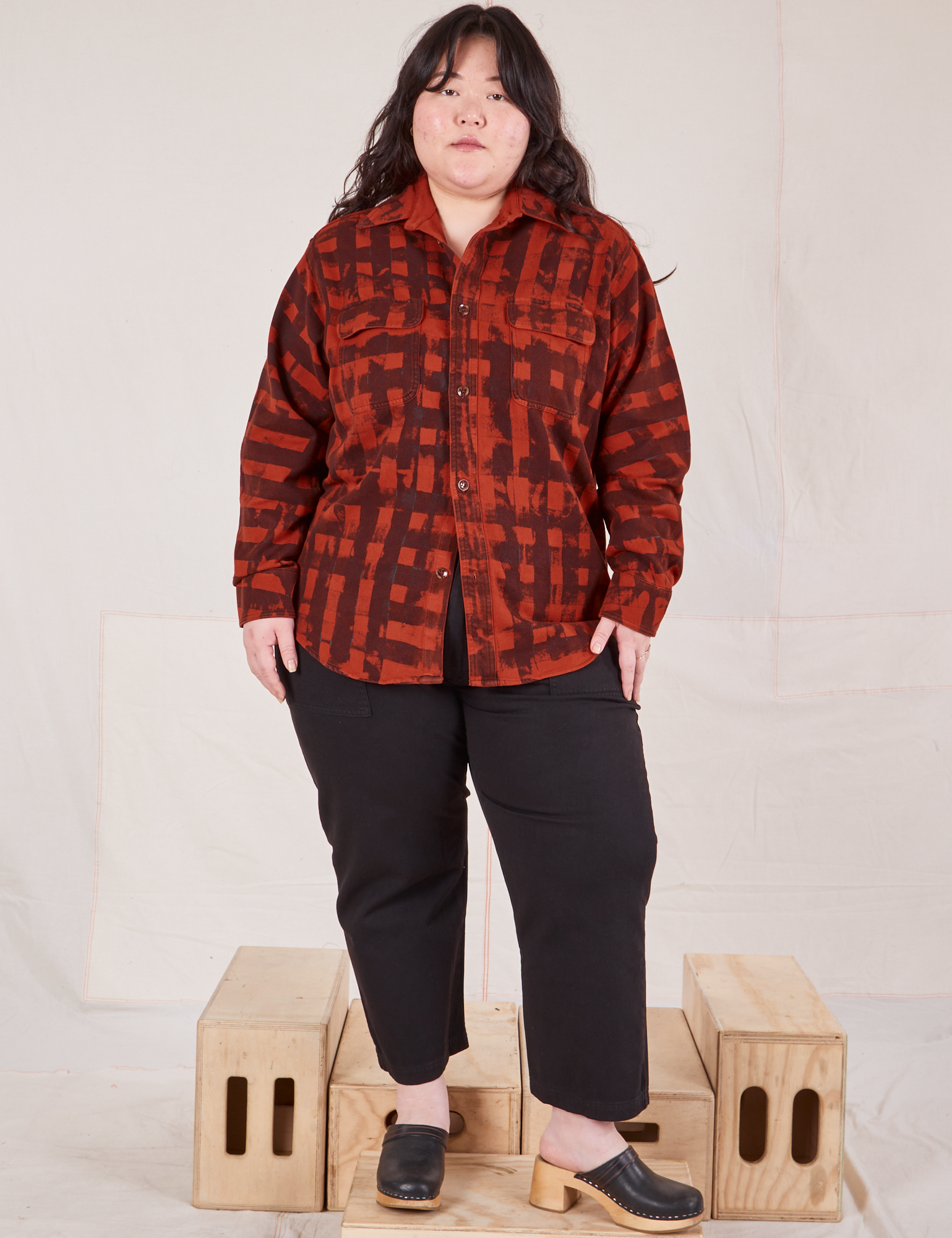 Ashley is wearing a buttoned up Plaid Flannel Overshirt in Paprika paired with black Work Pants