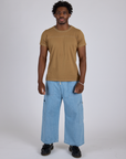 Isaac is wearing Jr. Varsity Tee in Desert Brown and light wash Denim Drop Pocket Pants