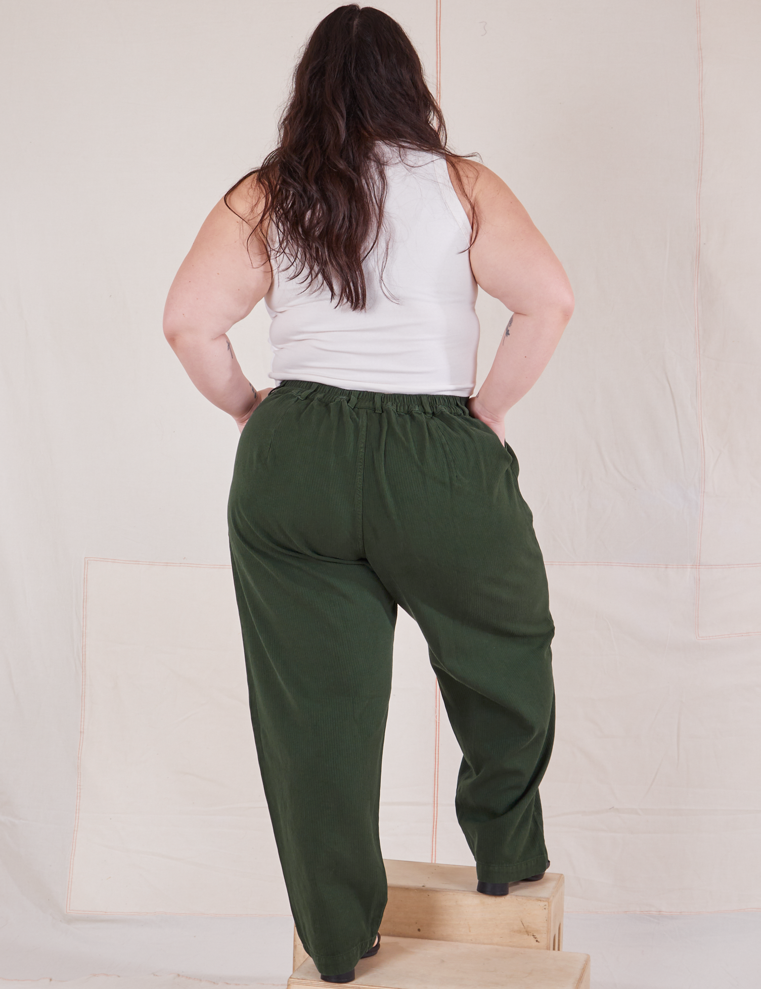 Back view of Heritage Trousers in Swamp Green and Cropped Tank Top in vintage tee off-white on Ashley