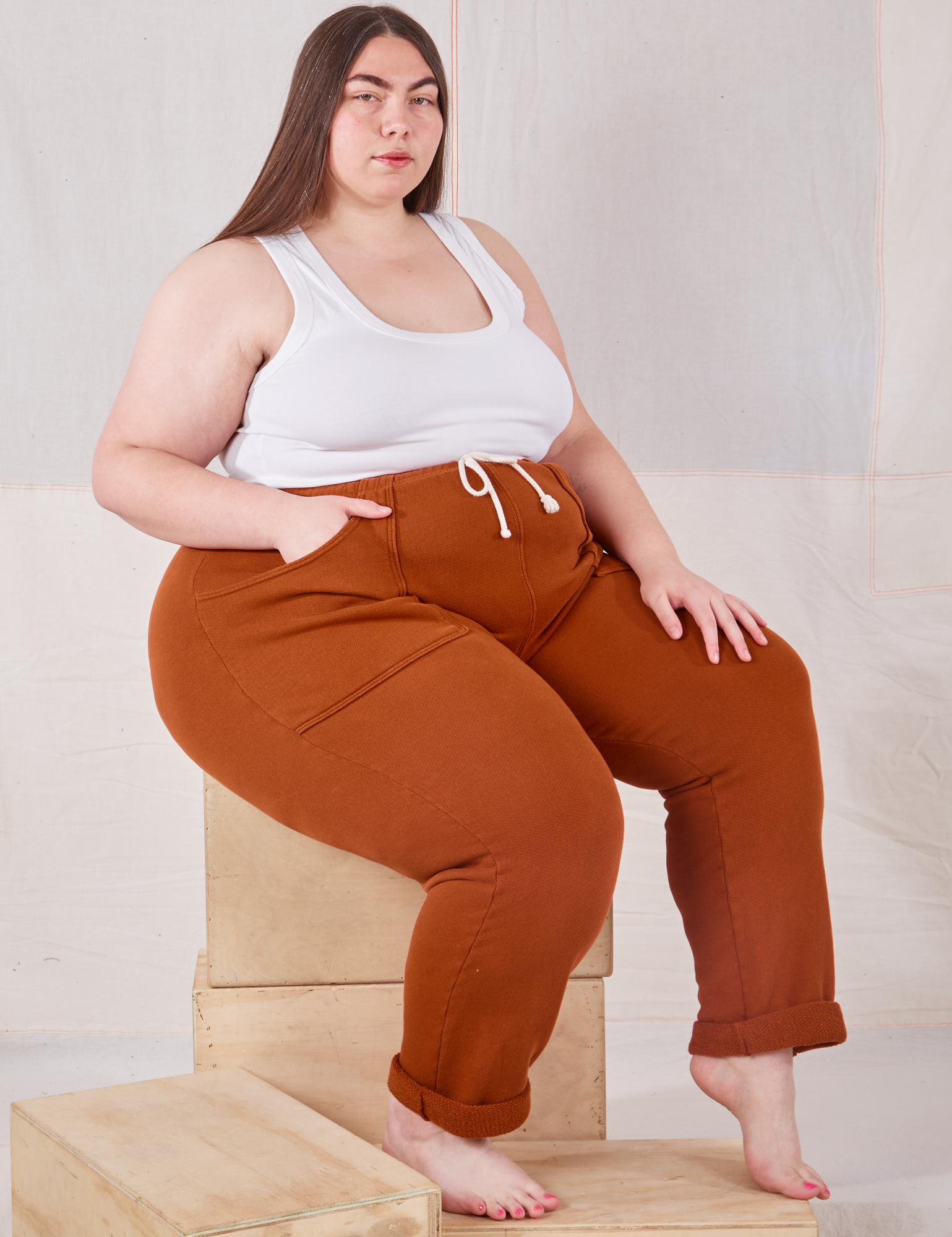 Marielena is wearing Rolled Cuff Sweat Pants in Burnt Terracotta and Cropped Tank in vintage tee off-white