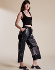 Angled front view of Magic Waters Drop Pocket Pants in Ink Blot and black Cropped Tank on Alex