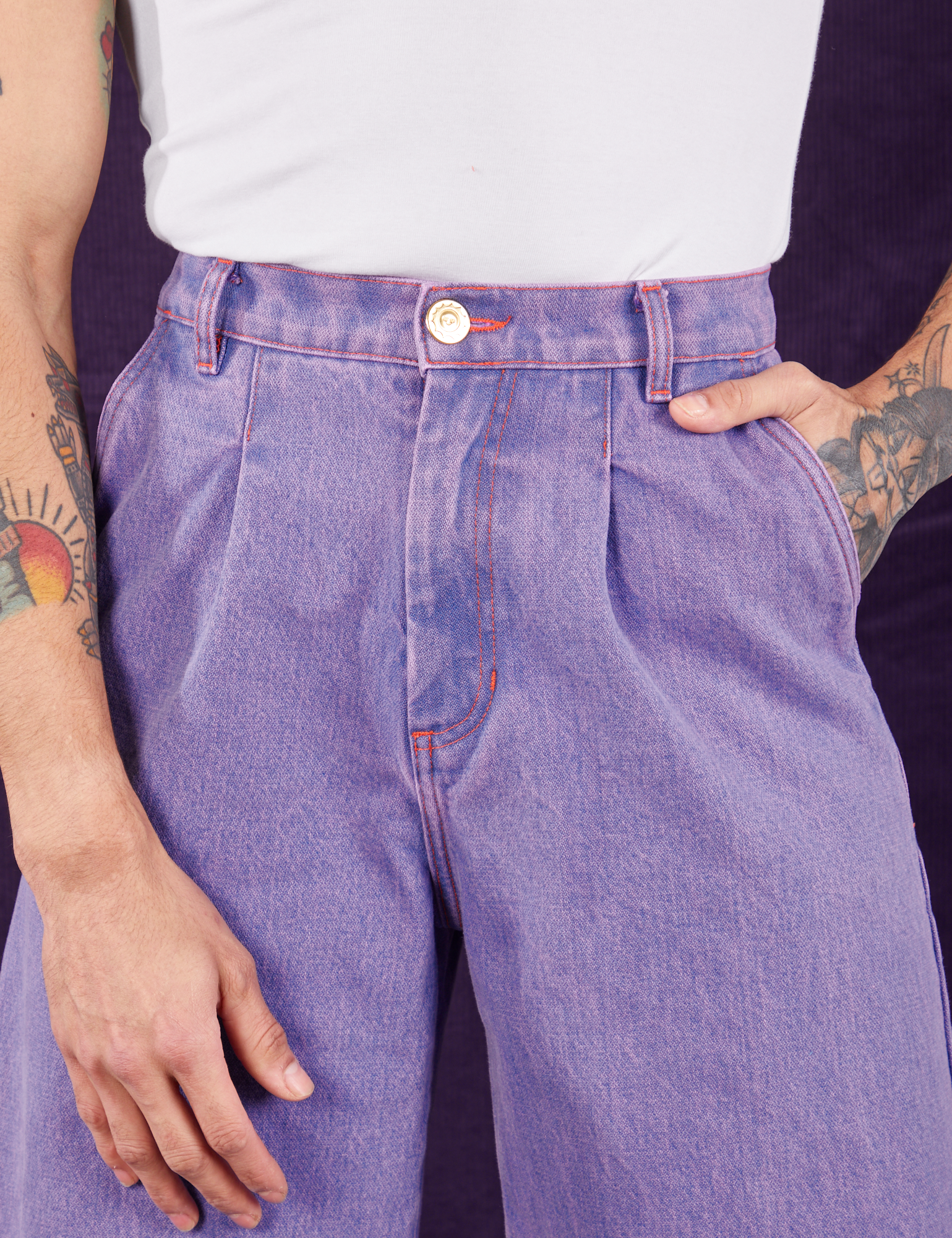 Overdyed Wide Leg Trousers in Faded Grape front close up on Jesse. They have their hand in the pocket.