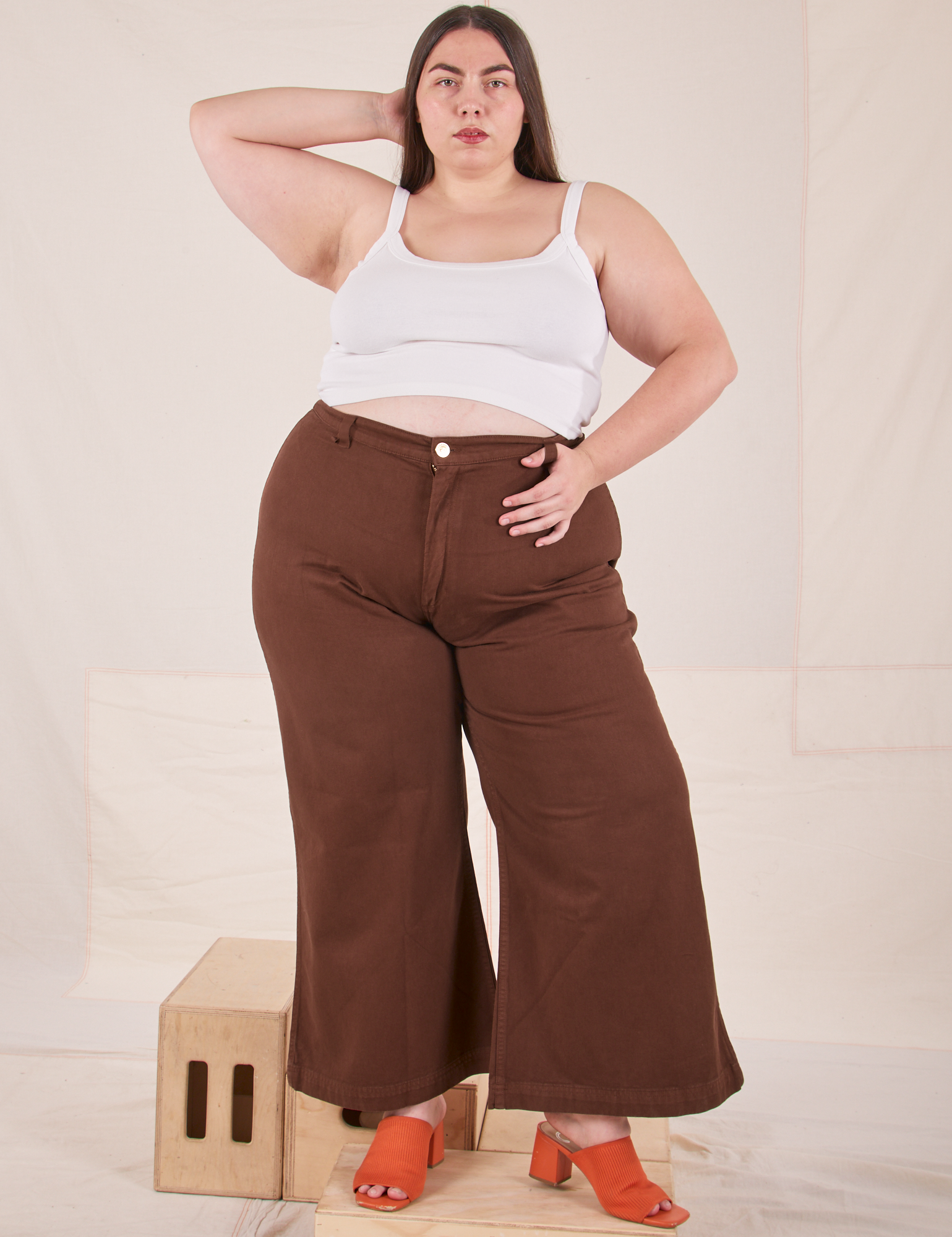 Marielena is 5&#39;8&quot; and wearing 2XL Bell Bottoms in Fudgesicle Brown paired with a Cropped Cami in vintage tee off-white