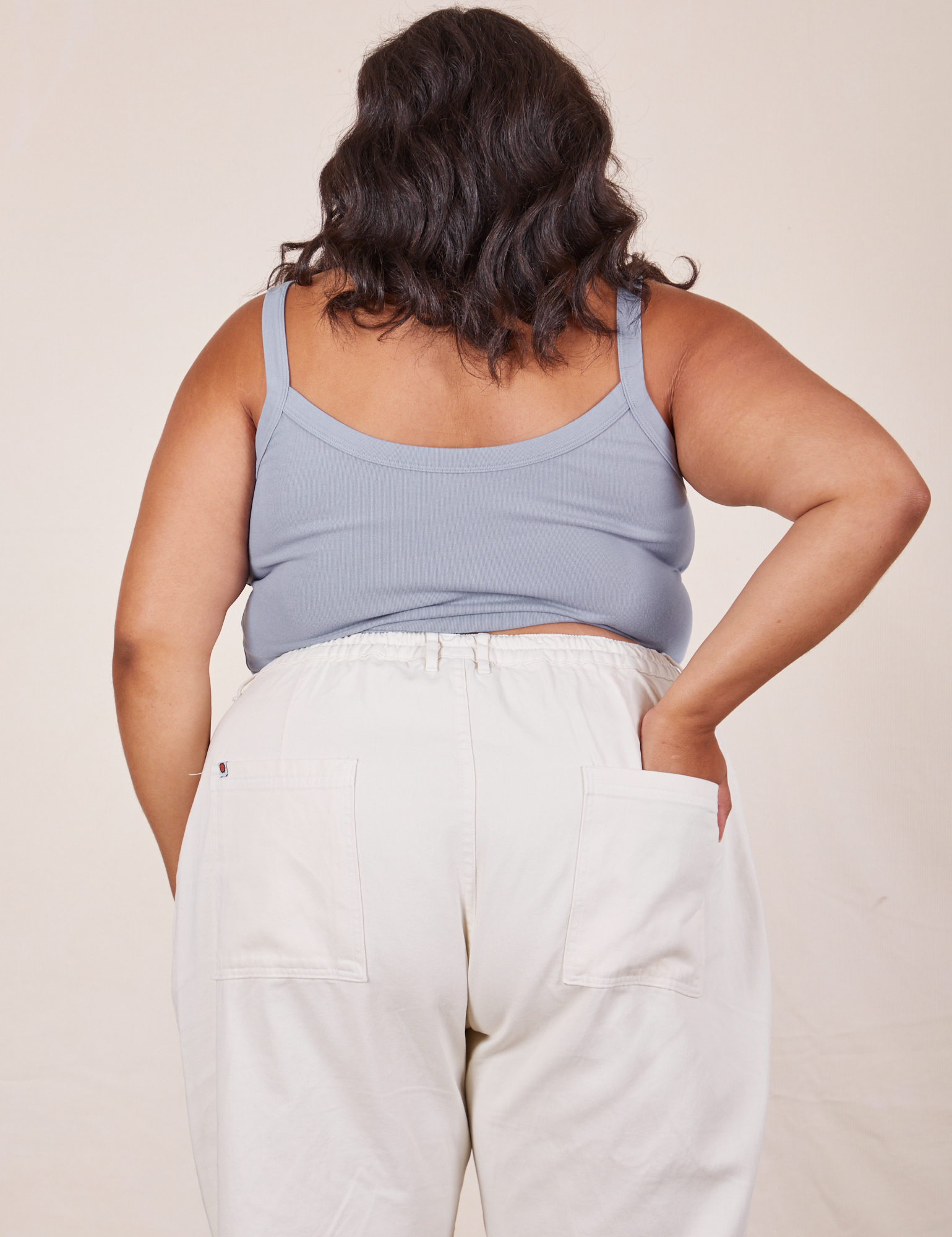 Back view of Cropped Cami in Periwinkle and vintage tee off-white Western Pants worn by Alicia. She has her right hand in the back pant pocket.