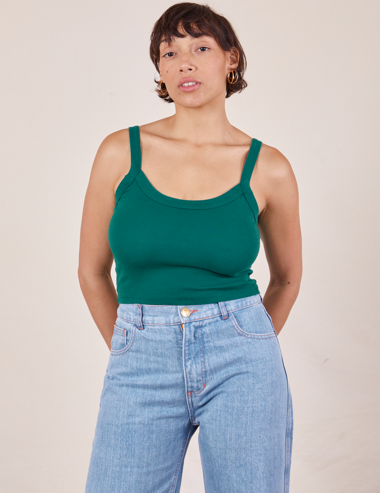 Tiara is 5&#39;4&quot; and wearing XS Cropped Cami in Hunter Green paired with light wash Frontier Jeans