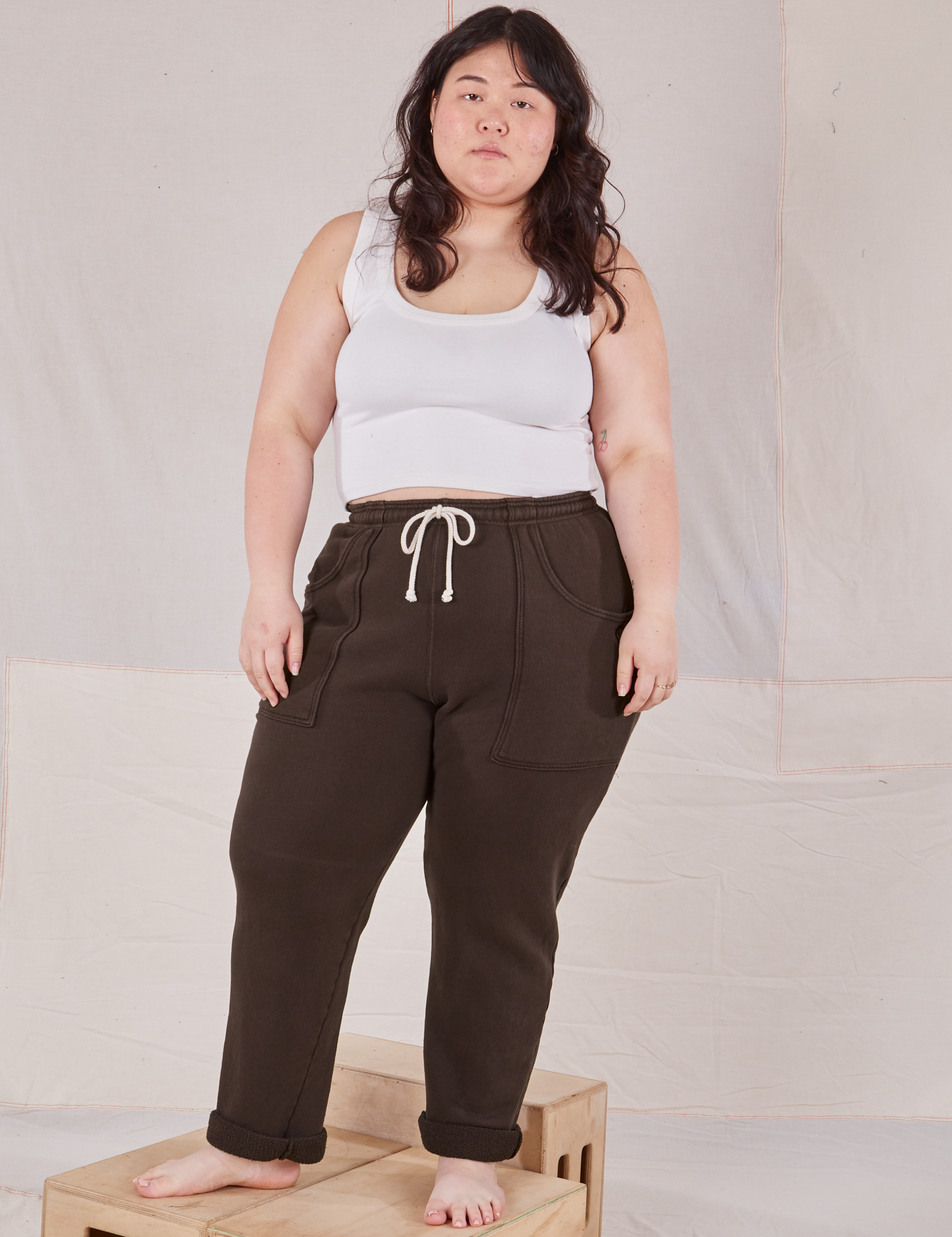 Ashley is 5&#39;7&quot; and wearing L Rolled Cuff Sweat Pants in Espresso Brown paired with Cropped Tank in vintage tee off-white