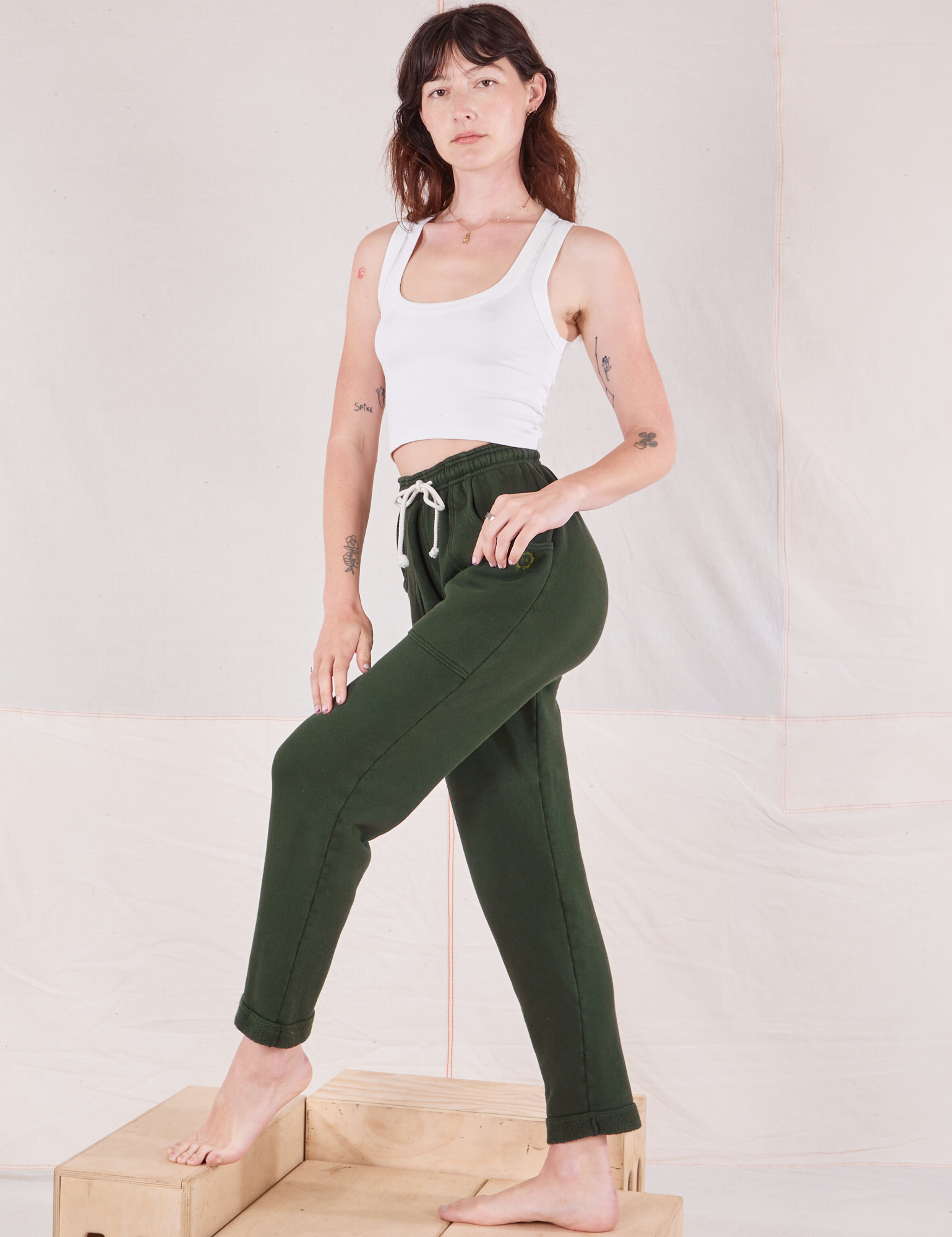 Alex is wearing Rolled Cuff Sweat Pants in Swamp Green and vintage off-white Cropped Tank Top