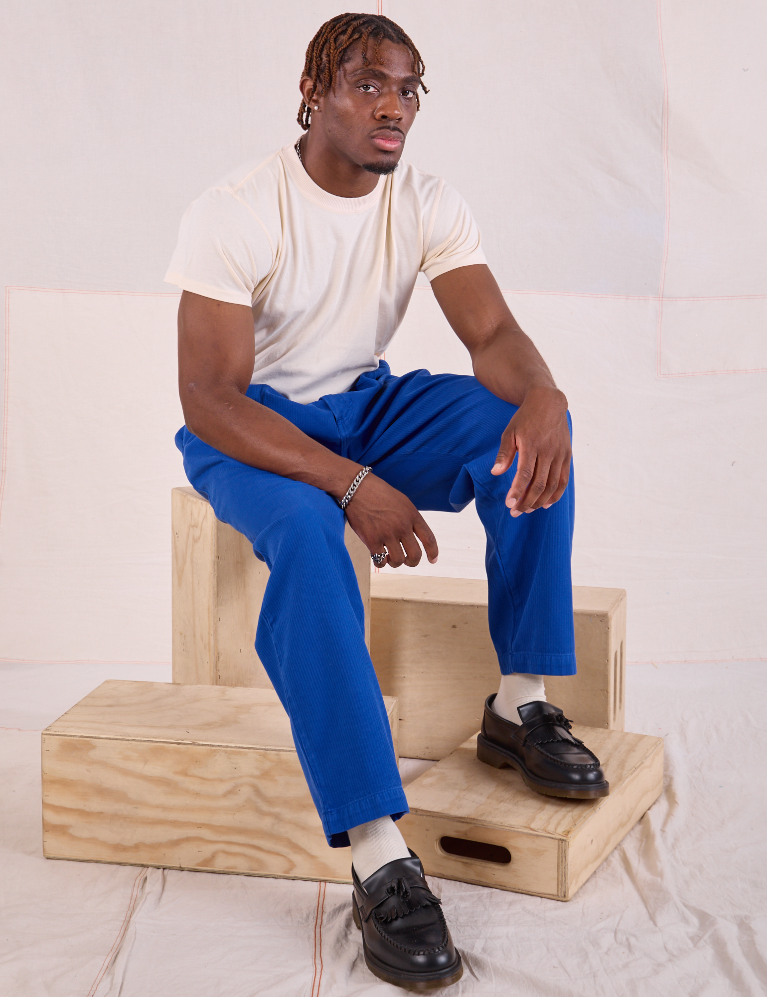 Issac is wearing Heritage Trousers in Royal Blue and Organic Vintage Tee in vintage tee off-white