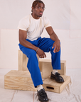 Issac is wearing Heritage Trousers in Royal Blue and Organic Vintage Tee in vintage tee off-white