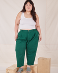 Ashley is 5'7" and wearing 1XL Petite Heavyweight Trousers in Hunter Green paired with Cropped Tank Top in vintage tee off-white