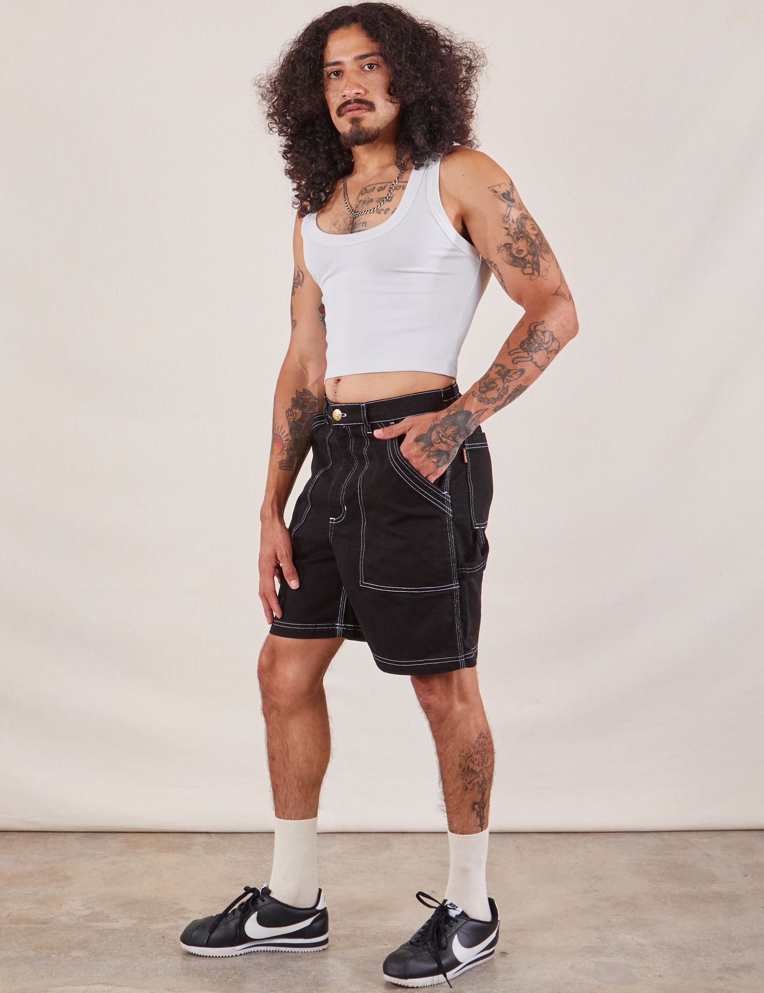 Jesse is wearing Carpenter Shorts in Basic Black and Cropped Tank in vintage tee off-white
