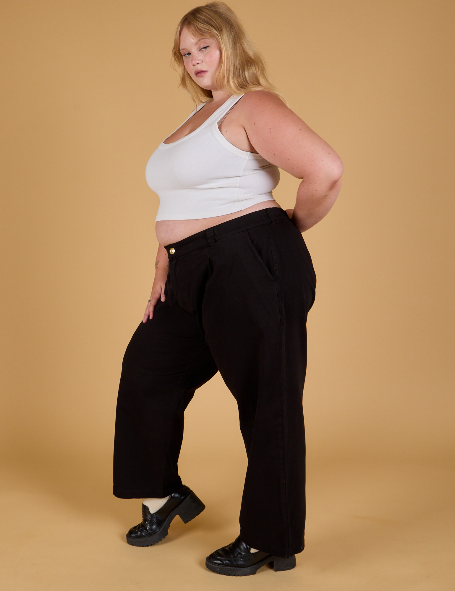 Side view of Baggy Mid-Rise Trousers in Basic Black and vintage tee white Cropped Tank on Juliet