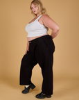 Side view of Baggy Mid-Rise Trousers in Basic Black and vintage tee white Cropped Tank on Juliet