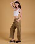 Side view of Baggy Mid-Rise Trousers in Desert Brown and vintage tee white Cropped Tank on Alex