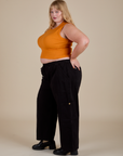 Side view of Muscle Tee in Creamsicle Orange and black Drop Pocket Cargo Pants on Juliet