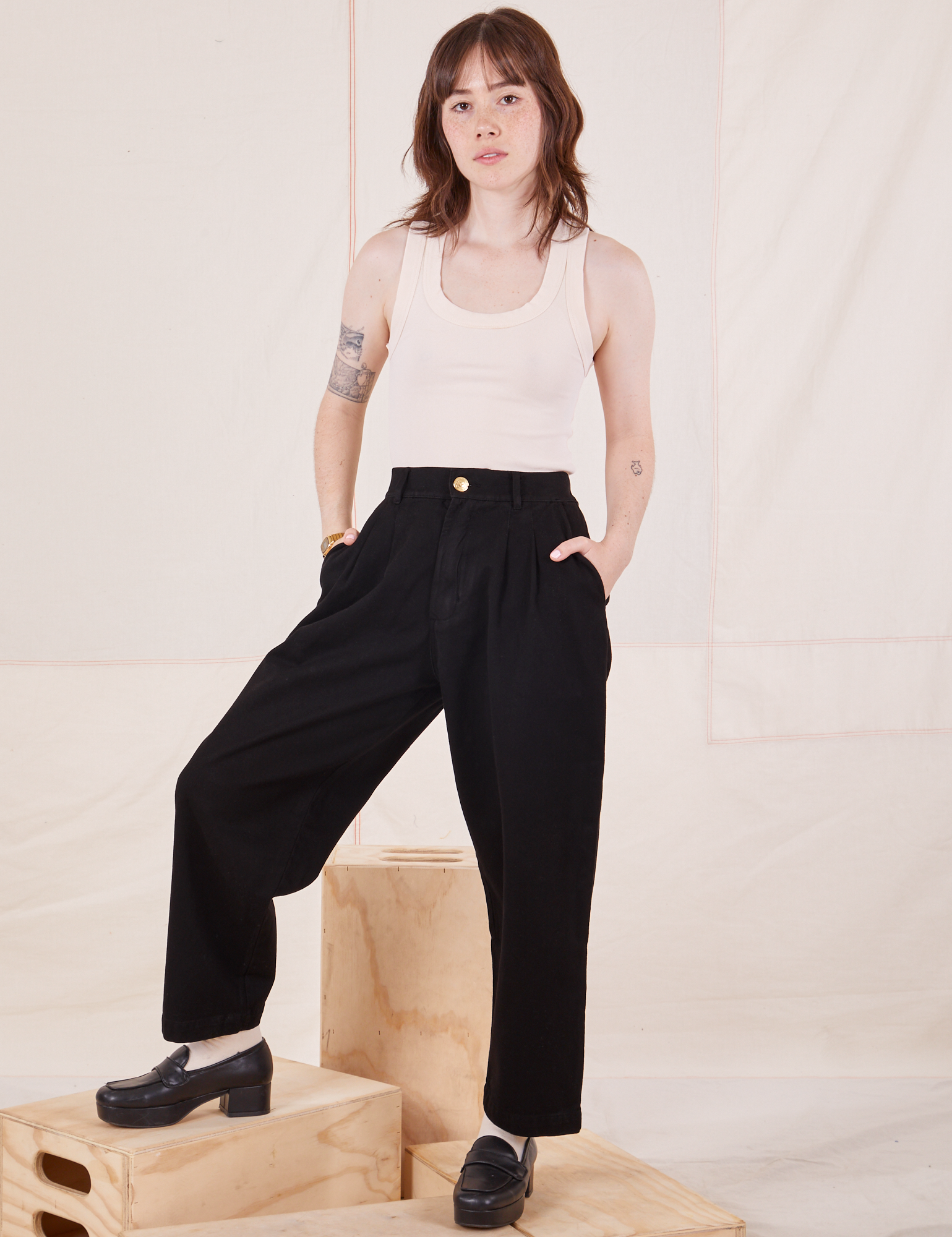 Hana is 5&#39;3&quot; and wearing XXS Petite Organic Trousers in Basic Black paired with Tank Top in vintage tee off-white